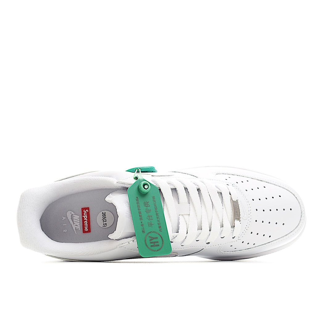 White low-top sneaker with green lacing tag and open interior showing sole lining