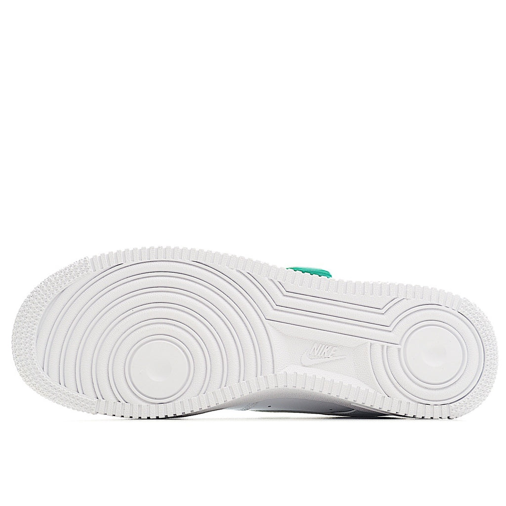 White sneaker outsole view with tread pattern and green heel tab