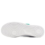 White sneaker outsole view with tread pattern and green heel tab