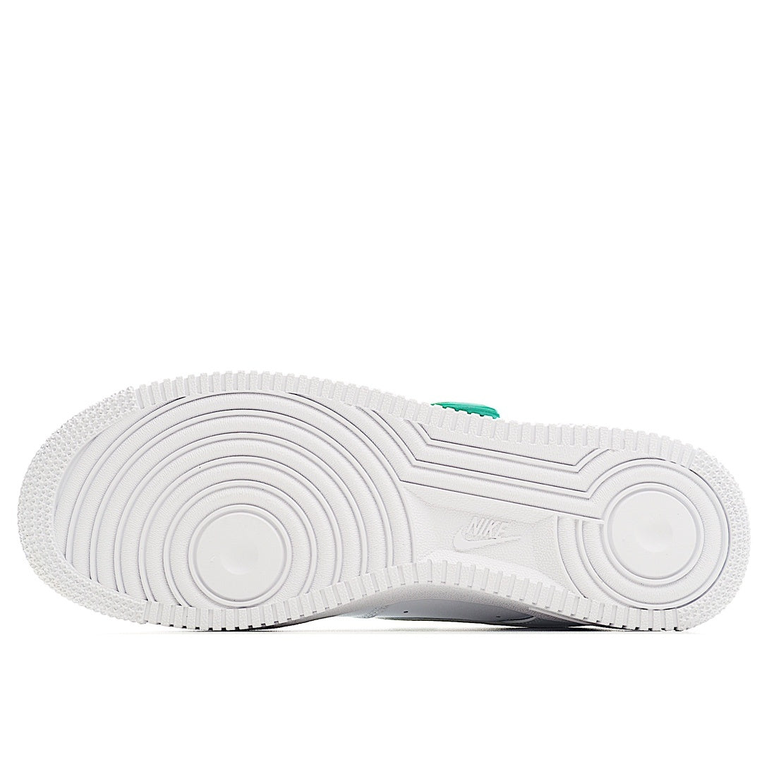 White sneaker outsole view with tread pattern and green heel tab
