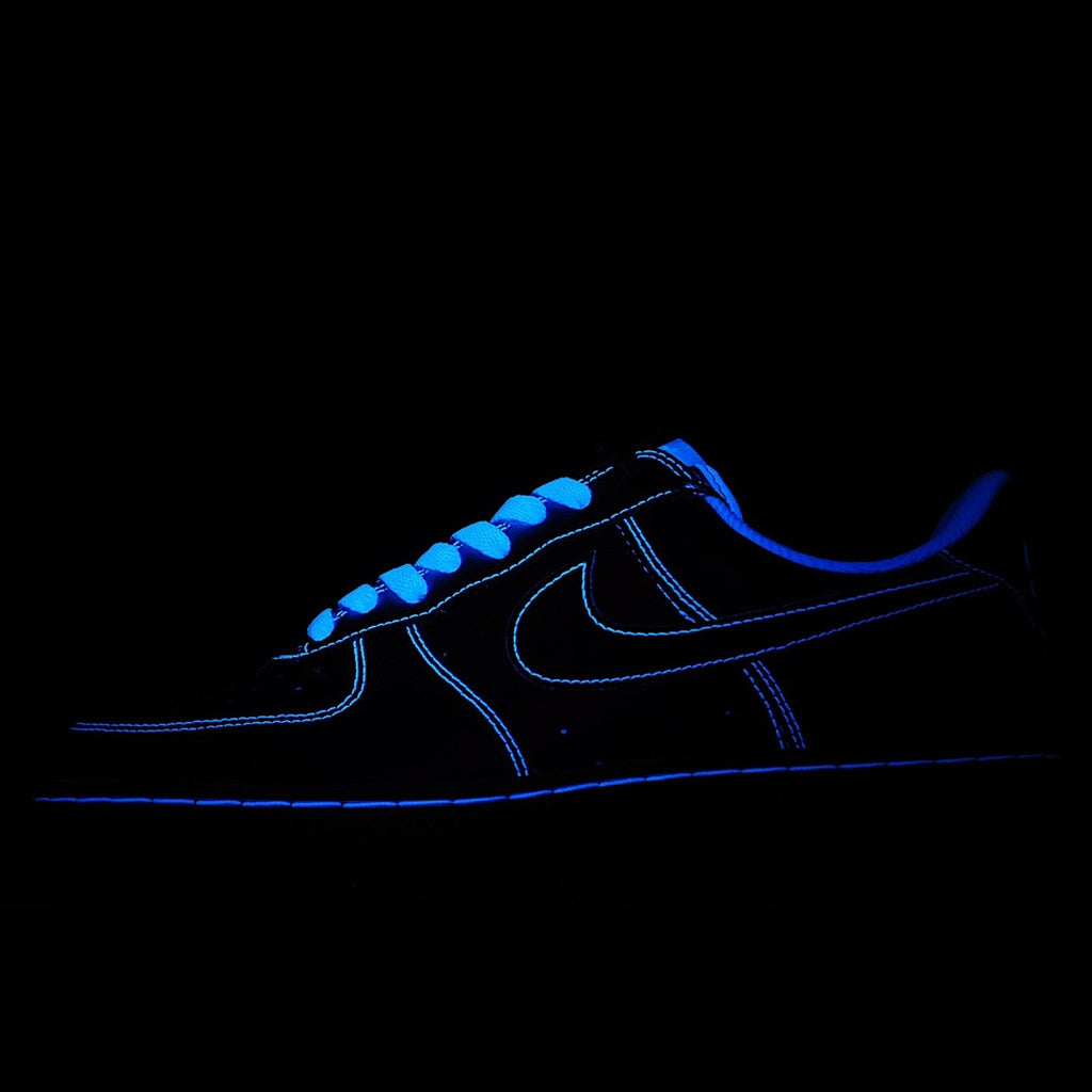 Blue low-top sneaker with neon-style Nike Swoosh and dark outsole