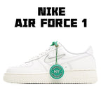 White Nike Air Force 1 low sneakers with green lace tag and swoosh logo