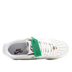 White Nike Air Force 1 low sneakers with Nike Air logo and green heel tag