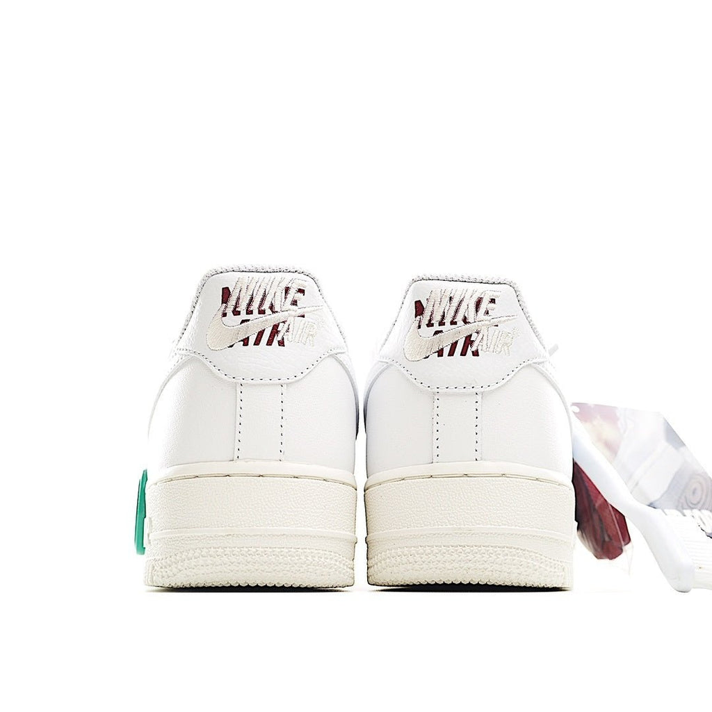 White Nike Air Force 1 low sneakers, back view, green lace pull and heel details