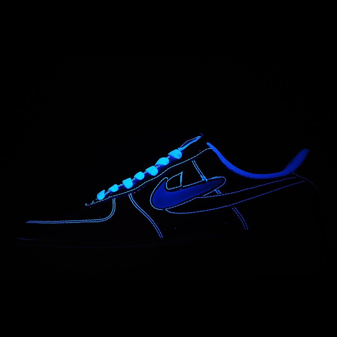 Dark Nike low sneaker with bright blue outline and swoosh accent