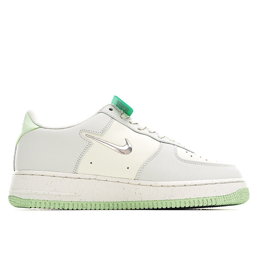 White low-top sneakers with green lace accents, swoosh logo, and flat textured sole