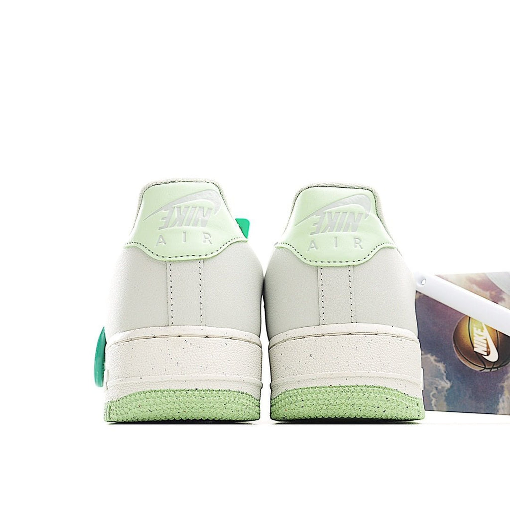 Pair of white low-top sneakers with green heel tabs and white rubber midsole