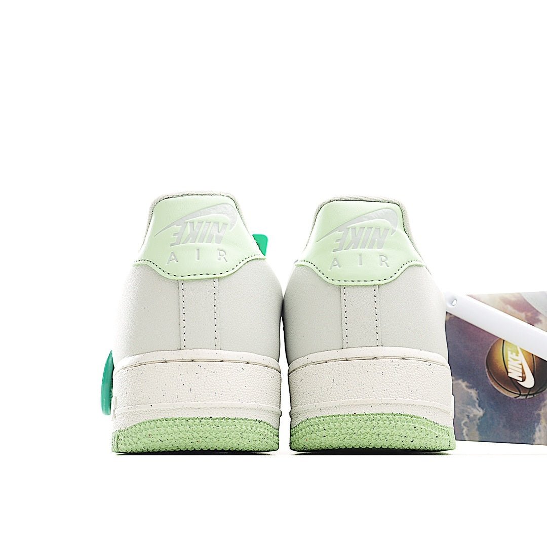 Pair of white low-top sneakers with green heel tabs and white rubber midsole