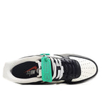 Low-top sneaker interior view, black and white upper with green lace label.