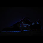 Dark low-top sneaker with blue swoosh outline detail.