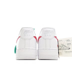 White sneakers with red and green heel accents, back view