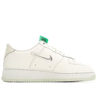 White Nike sneakers with grey swoosh and green heel tab