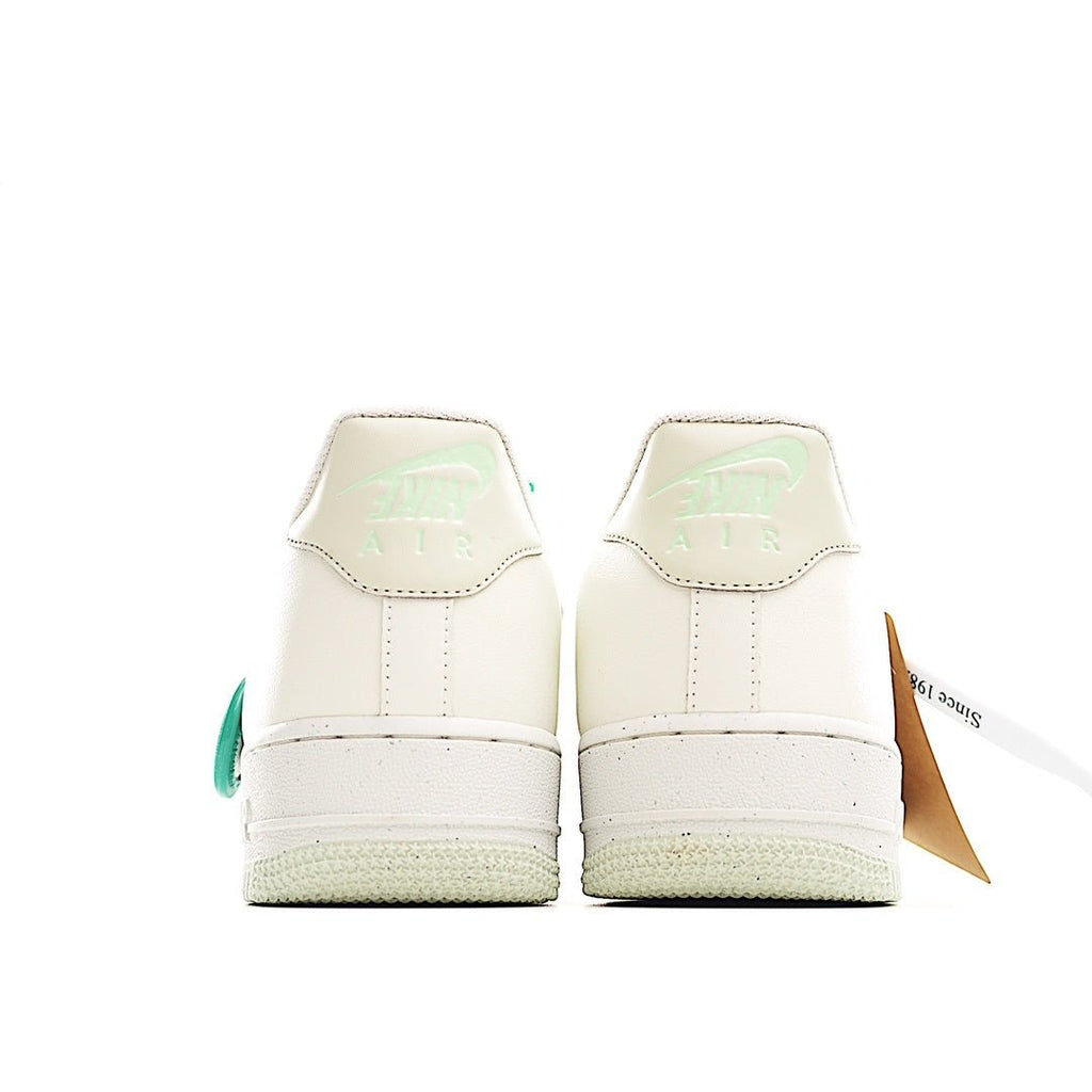 White Nike sneakers, heel view, with green back tab accents