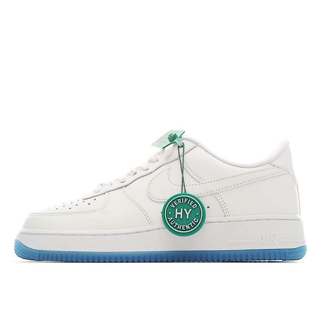 White low-top sneakers with light-blue outsole; side Swoosh logo and lace-up closure
