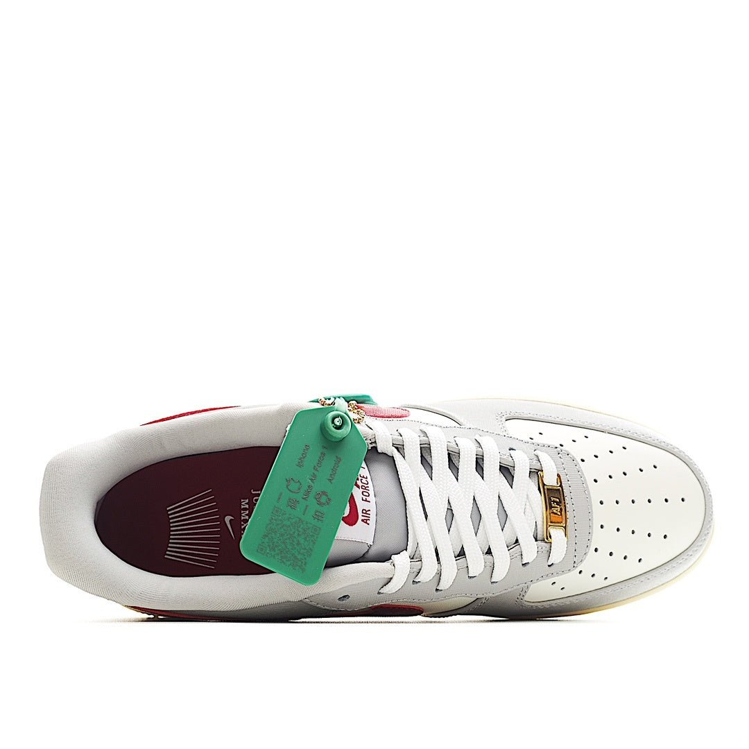 White Air Force 1-style sneakers with maroon interior lining and green hang tag