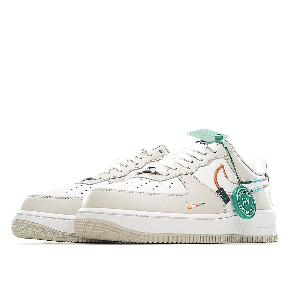 White low-top sneakers, side view with teal heel tab and orange swoosh