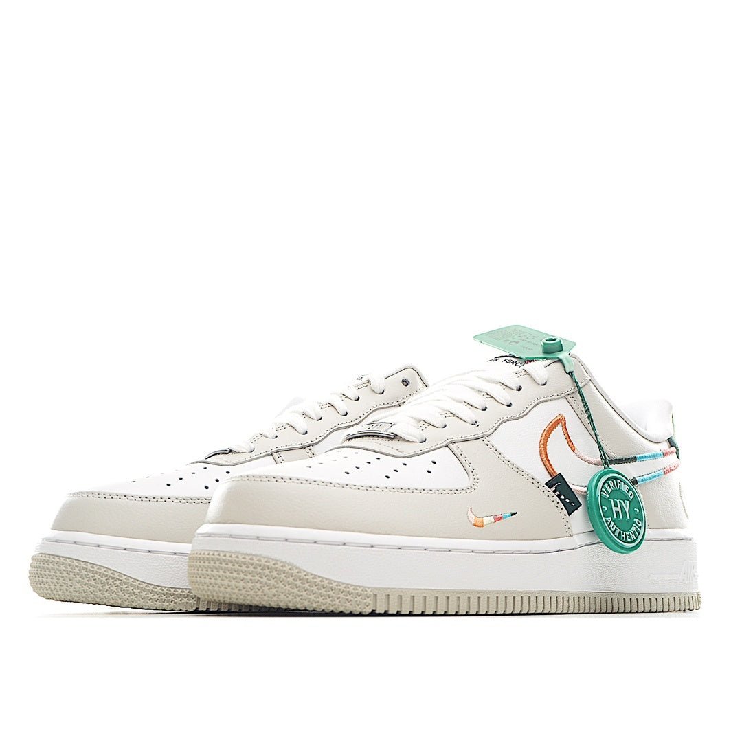 White low-top sneakers, side view with teal heel tab and orange swoosh