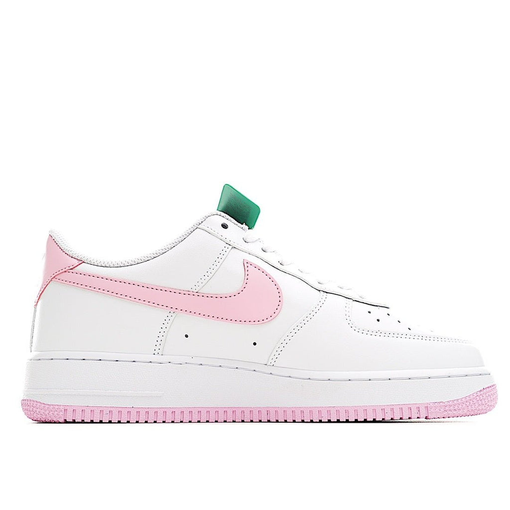 White Nike Air Force 1 sneakers with pink swoosh, green lace tag, and pink outsole