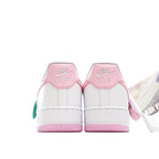 White Nike Air Force 1 sneakers with pink heel accents and green tag