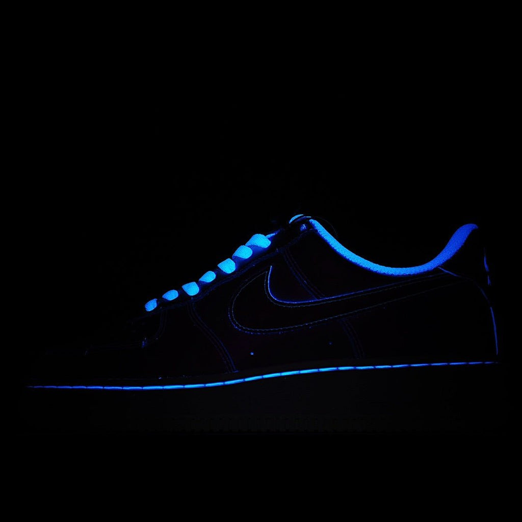 Low-top sneakers, dark navy/black upper with blue swoosh and glowing trim