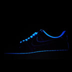 Low-top sneakers, dark navy/black upper with blue swoosh and glowing trim