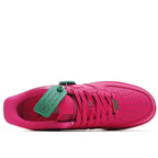 Pink Nike Air Force 1 low-top sneaker with green tag at tongue