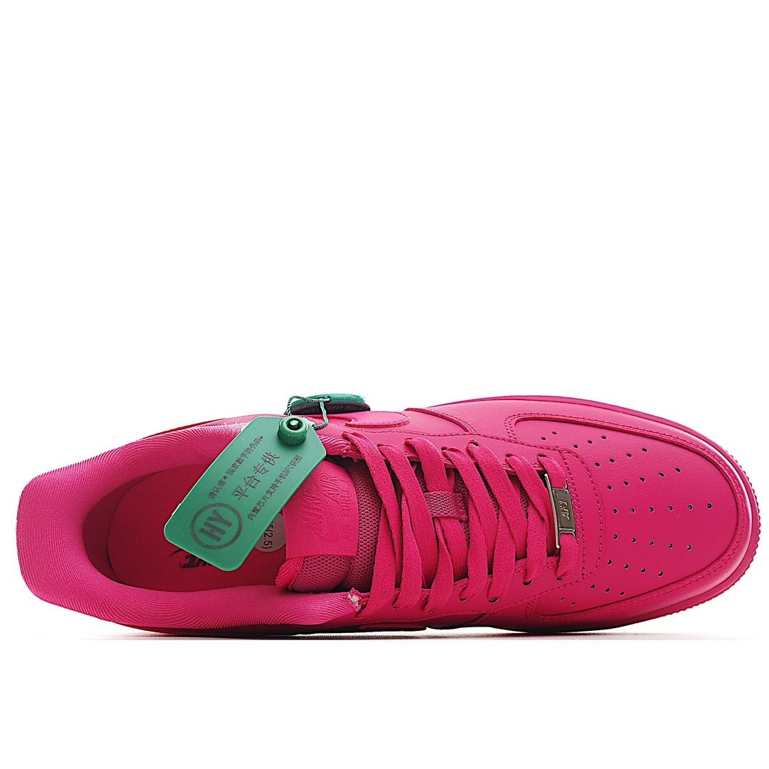 Pink Nike Air Force 1 low-top sneaker with green tag at tongue