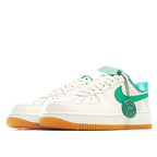 White low-top sneakers with green Swoosh and teal heel panel, lace-up front, gum outsole