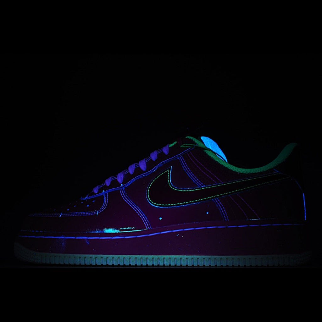 Dark low-top sneakers with blue and green neon accents, lace-up front