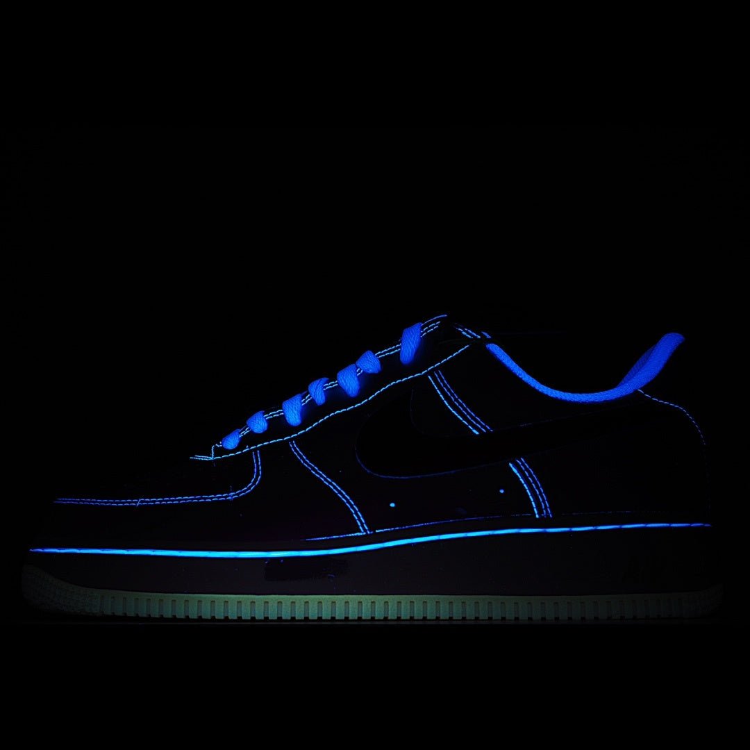 Nike Air Force 1 sneakers, dark upper with blue neon accents and glow sole