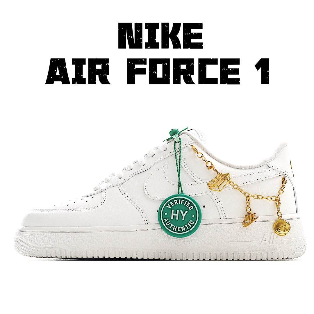 White low-top sneakers with green laces and gold chain charm detail