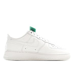 White low-top sneakers with green heel tab, side view