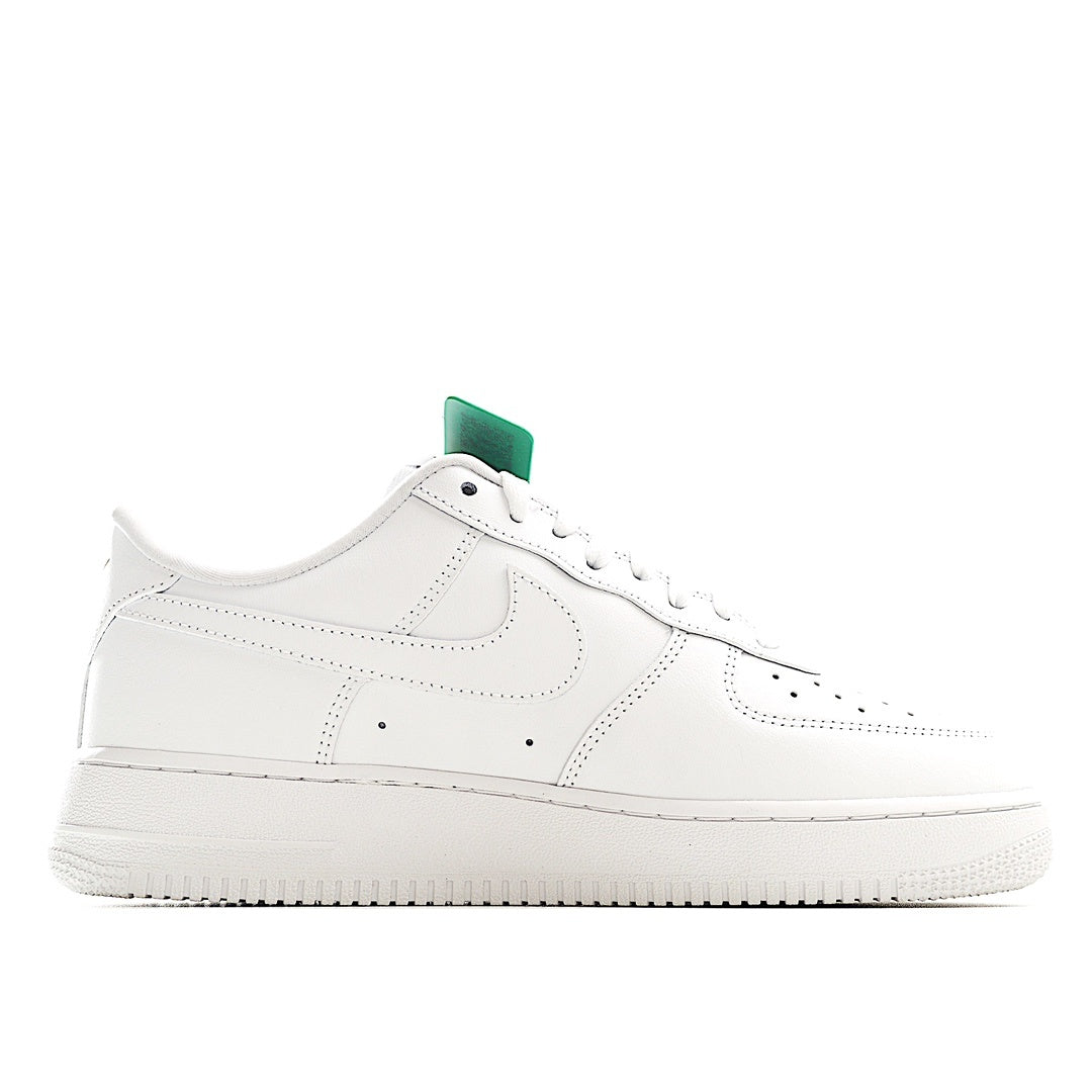 White low-top sneakers with green heel tab, side view