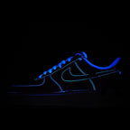 Dark blue low-top sneakers with neon-blue outline, glowing side view