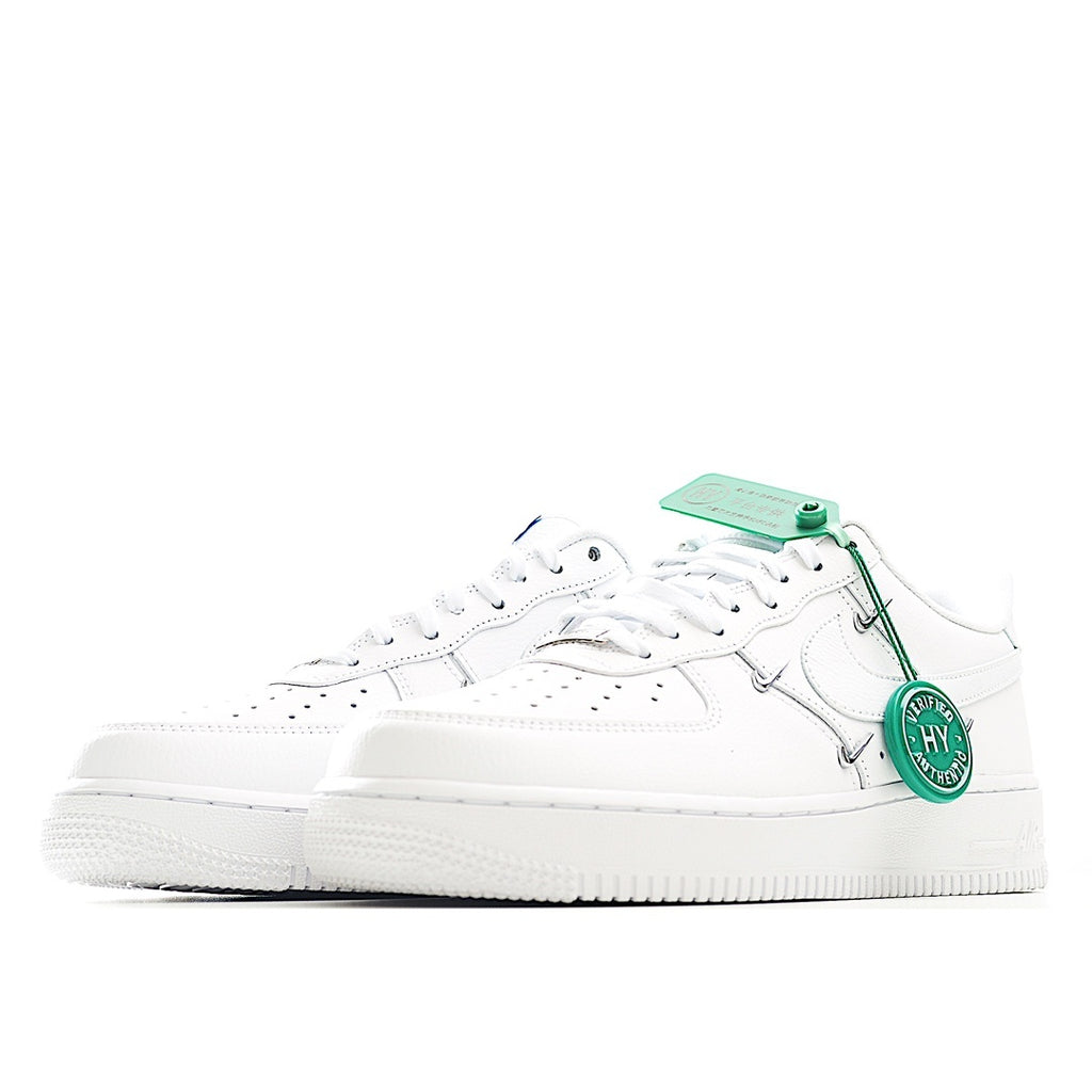 White low-top sneakers with green lace tips and side strap