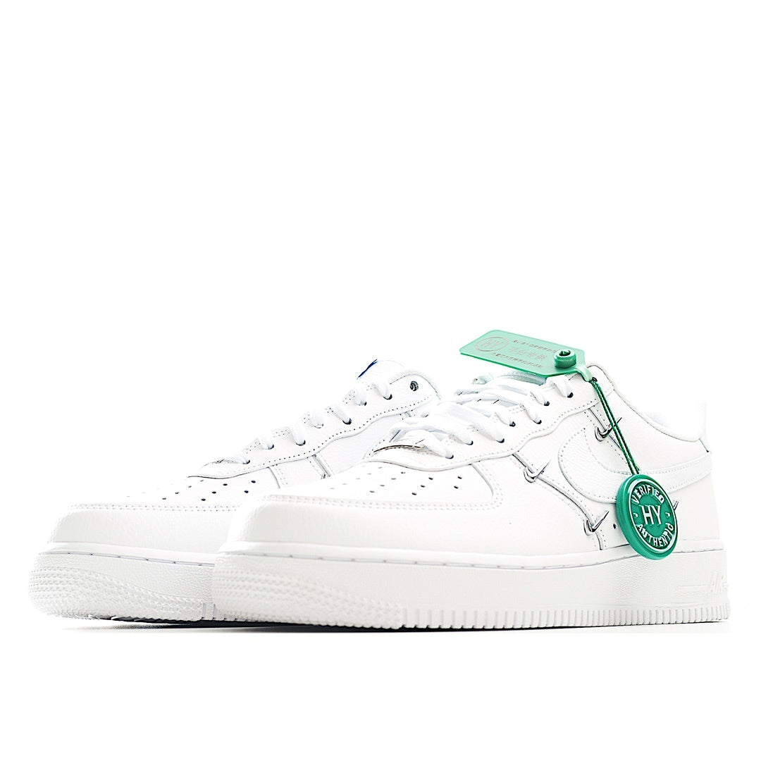 White low-top sneakers with green lace tips and side strap