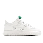White low-top sneakers, side profile with green-accent lace panel
