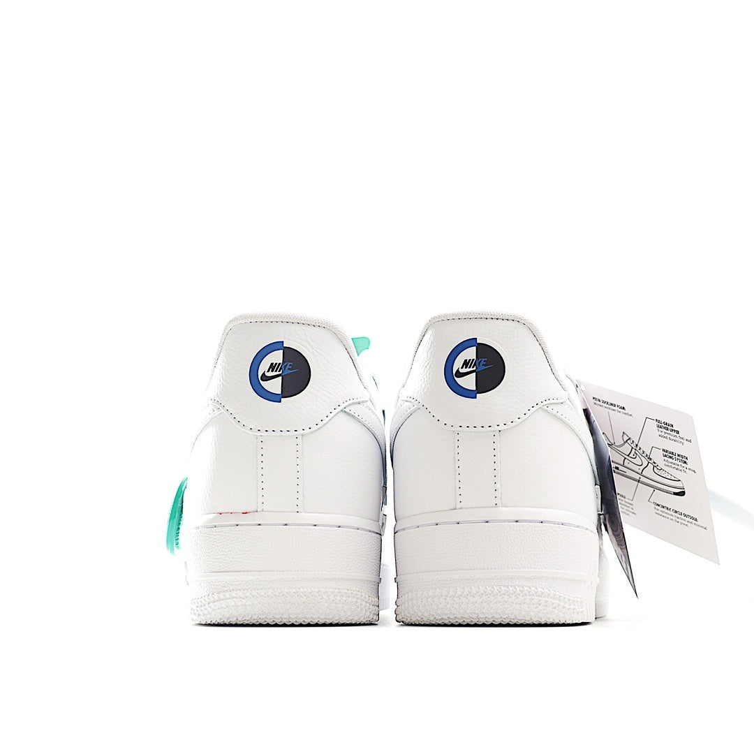 White low-top sneakers with blue heel logo and green pull tab
