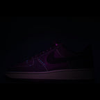 Dark purple-accent low-top lace-up sneaker with swoosh detail