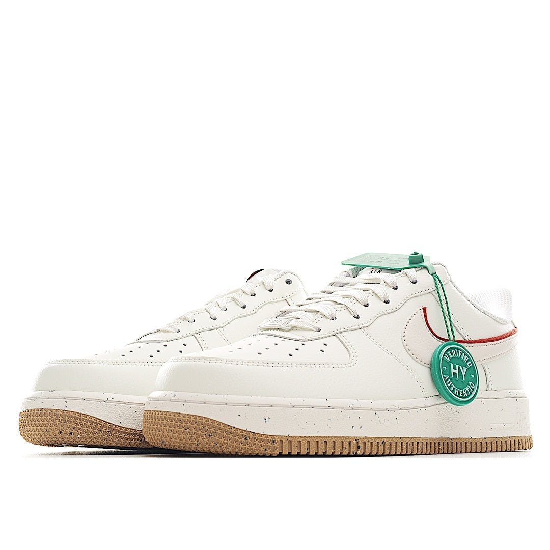 White Nike Air Force 1 sneaker side view with red swoosh, green HY tag, gum sole