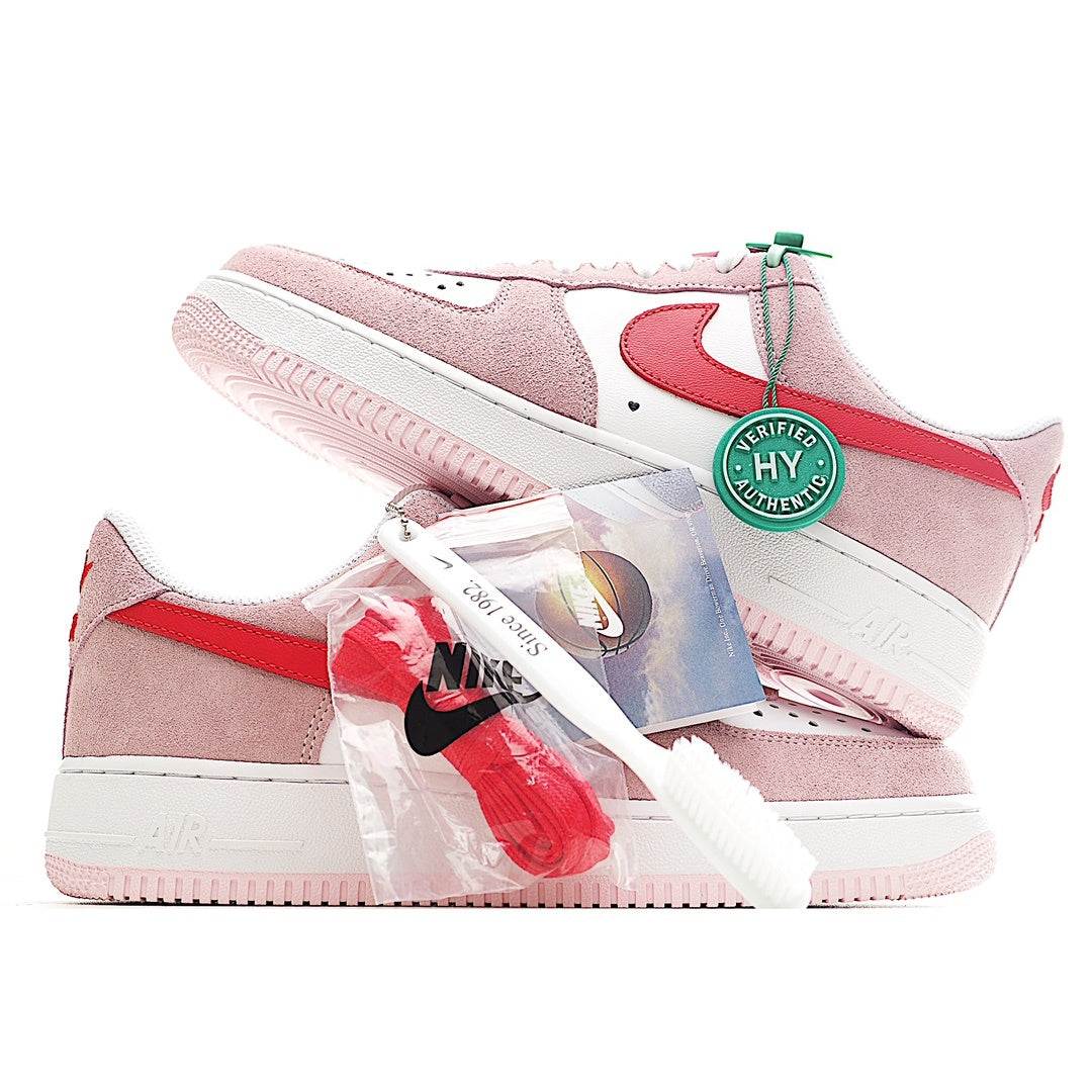 Nike Air Force 1 sneakers pair, pink suede with red swoosh, white sole and green tag