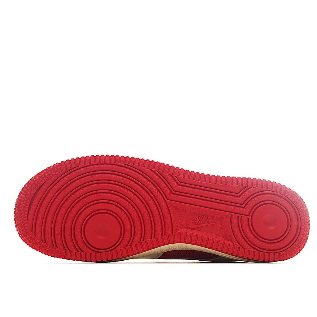 Red rubber outsole with circular traction pattern under low-top sneakers