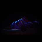 Low-top sneakers with dark upper and blue glowing swoosh accents