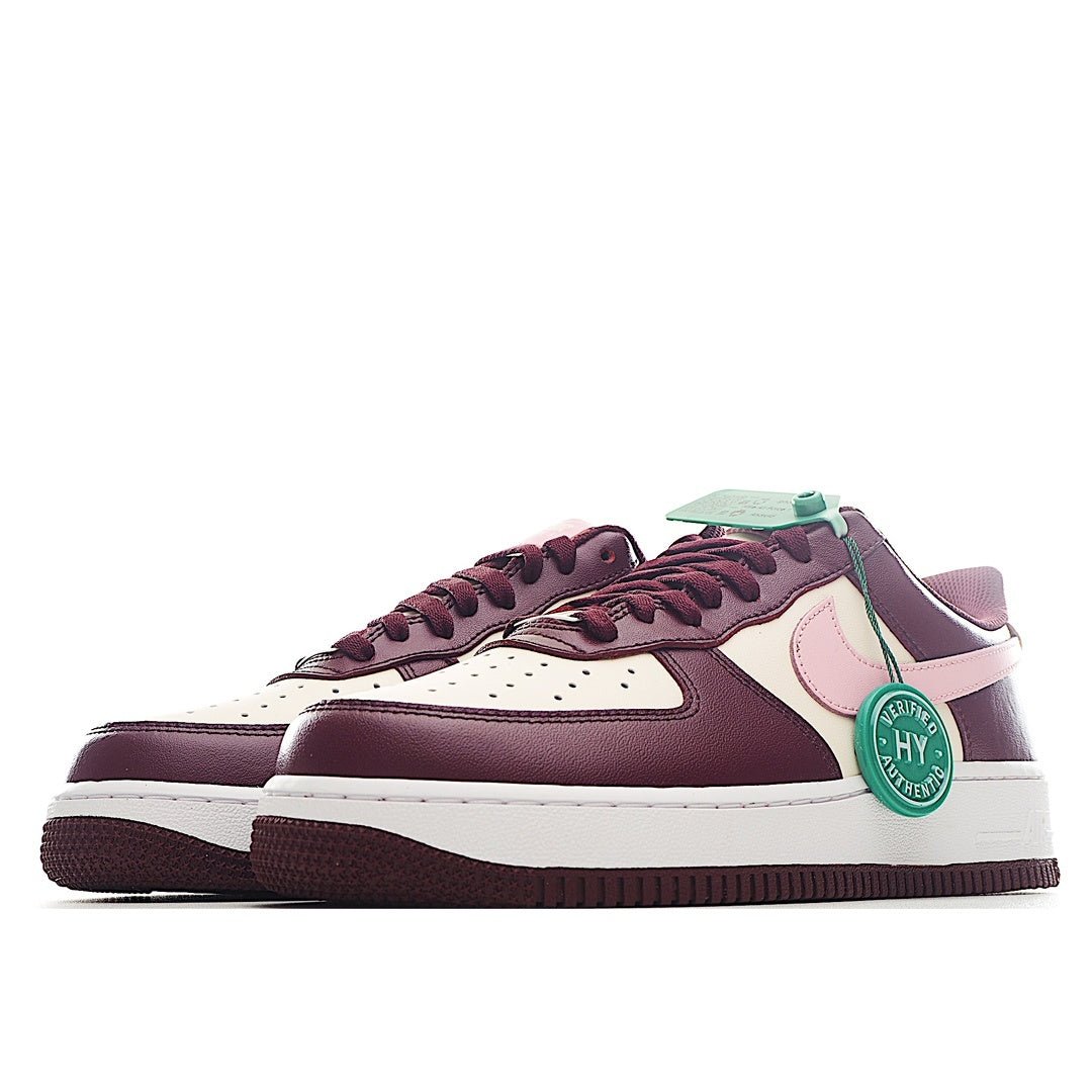 Nike Air Force 1 low-top sneaker pair in burgundy and white with pink panel and green tag