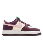 Nike Air Force 1 low-top sneaker with burgundy overlays, white toe, pink swoosh, green lace tag