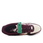 Nike Air Force 1 sneaker close-up, burgundy and white with green HY tag at tongue