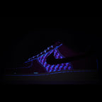 Dark low-top sneakers with blue-purple patterned upper and black sole.
