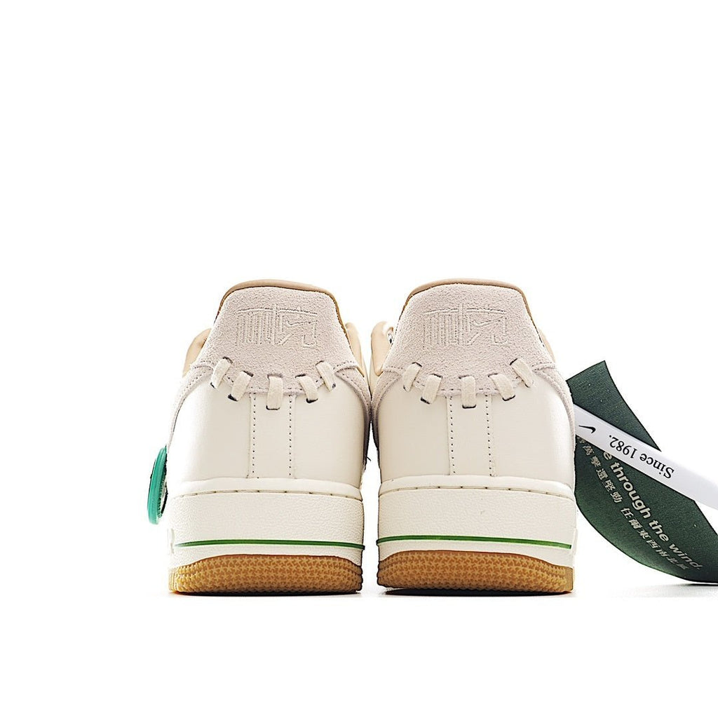 Nike Air Force 1 low-top sneaker, white back view with green accents and tan rubber sole
