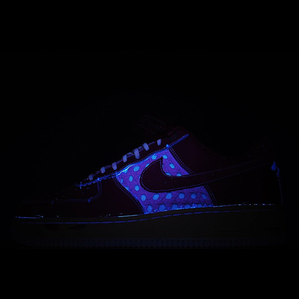 Low-top Nike sneaker in dark tones with blue upper and neon-style trim