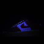 Low-top Nike sneaker in dark tones with blue upper and neon-style trim